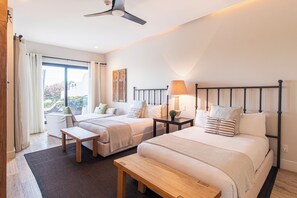 A hotel room with two beds, a bench, a table, and a ceiling fan. - Villa Perdiz, Puerta del Sol | 4 Bed, 4 Bath (Cabo San Lucas)