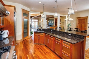 A spacious kitchen with wooden cabinets, granite countertops, and stainless steel appliances.