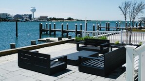 Eine Uferterrasse mit Sitzgelegenheiten und Blick auf das Wasser.