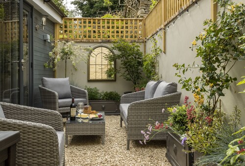 This charming Cotswold stone cottage, elegantly furnished with a seamless blend of antique and conte