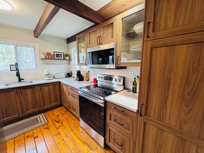 A kitchen with wooden cabinets, a stainless steel stove, and a microwave.