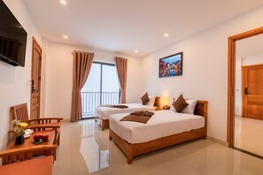 A hotel room with two beds, a dining table, and a TV. - Tomorrow Villa Hoi An (Da Nang)