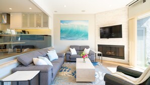 A modern living room with a gray sofa, a coffee table, and a fireplace. - Steps to Sand, Luxury Family Townhome with Central A/C BBQ Crib Resort Amenities (Solana Beach)