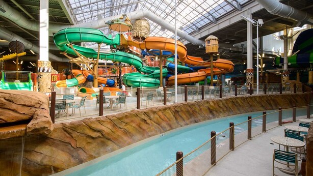 An indoor water park with multiple water slides and a pool area.