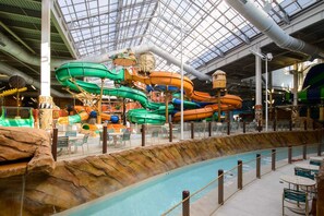 An indoor water park with multiple water slides and a pool area.