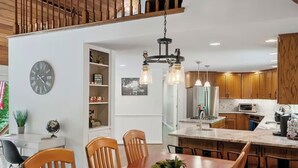 Une cuisine moderne avec des meubles en bois, un îlot central et des luminaires suspendus.