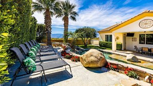 A poolside area with lounge chairs, a small pool, and a building with a yellow facade. - NEW: Pool, Spa, Tiki Bar, Mini Golf, Firepit, Desert Views (Desert Hot Springs)