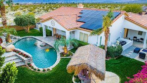 A house with a swimming pool, solar panels, and a mountain view. - NEW: Pool, Spa, Tiki Bar, Mini Golf, Firepit, Desert Views (Desert Hot Springs)