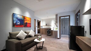 A modern living room with a sofa, coffee table, and artwork on the wall. - The Dream Suite (Da Nang)