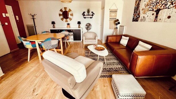 A modern living room with a sofa, a coffee table, a dining table with chairs, and a fireplace. - LE TERRACOTTA T4 SLEEPS 6, AIR-CONDITIONED, WITH PARKING SPACE (Caluire-et-Cuire)