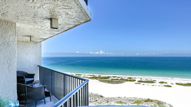Un balcon avec vue sur une plage et l’océan.