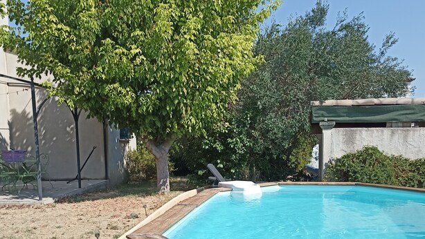A wooden deck surrounding a rectangular swimming pool with a wooden deck edge. - VILLA VAUNAGE (Calvisson)