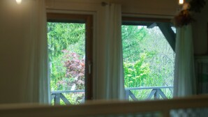 A room with two windows, each with a view of greenery outside. - FamC (Nakafurano)