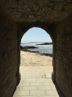 An arched stone structure leading to a sandy beach with a view of the sea. - A quiet, bright apartment on the coast of Brittany, just 1 minute from the beach. (Port-Louis)