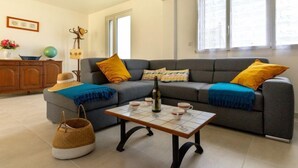 A living room with a grey sofa, a coffee table, and a wicker basket. - l'Emeraude by Interhome (Saint Cast le Guildo)