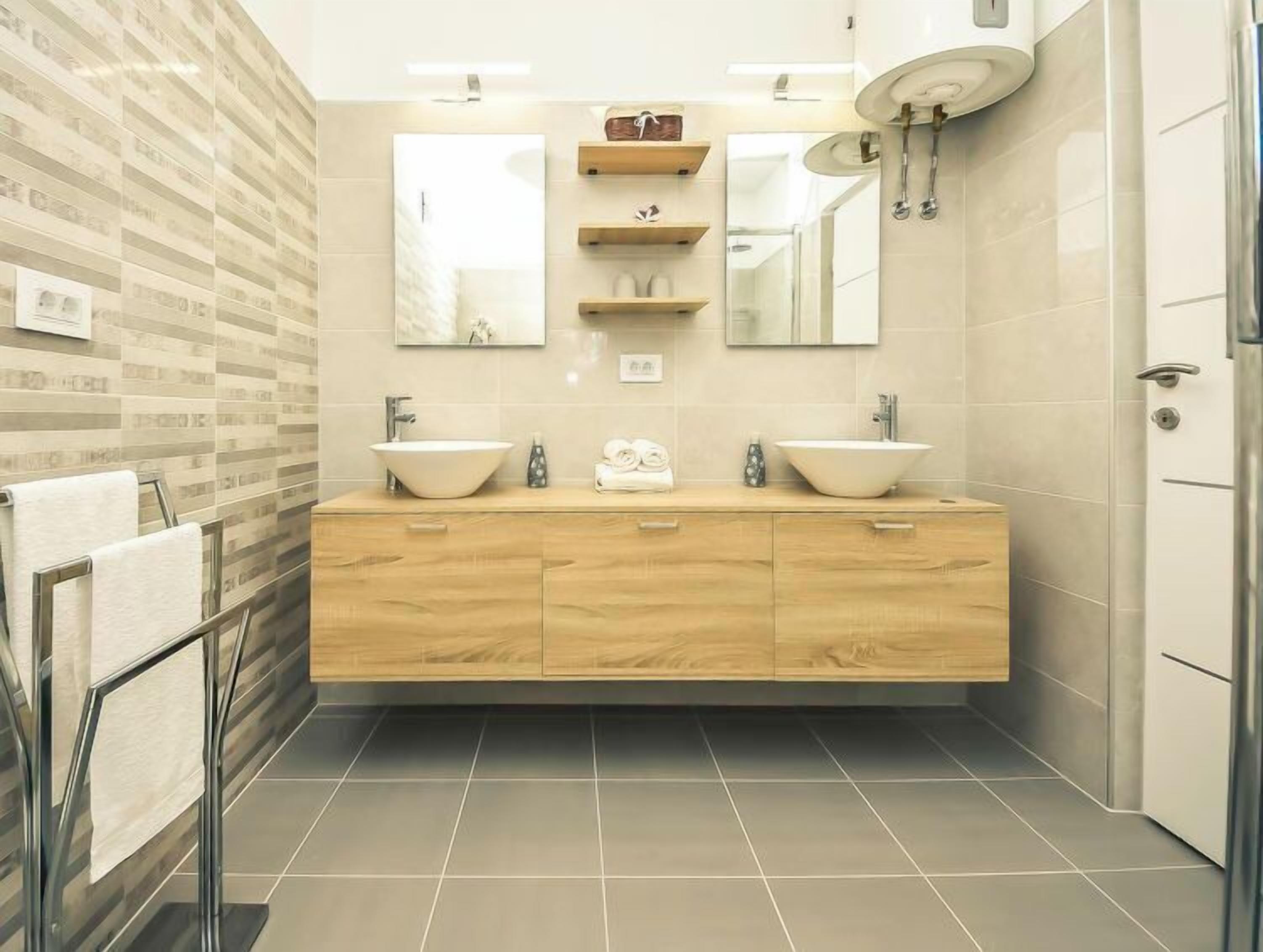 A modern bathroom with two sinks, a mirror, and a shower.