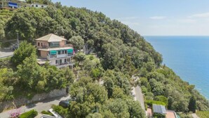 A coastal property with a large house surrounded by dense greenery, a road, and a clear view of the sea. - Lambrusca by Interhome (Moneglia)