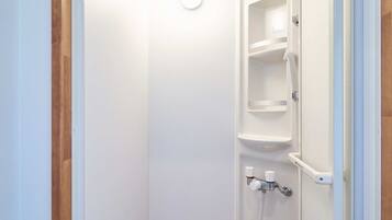 Een badkamer met een witte deur, een handdoekhouder en een zeepdispenser.