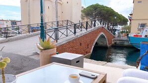 A table with a cup of coffee, a smartphone, and a menu at a seaside café. - 2 BEDROOM HOUSE IN PORT COGOLIN (with pontoon for boat) (PORT COGOLIN)