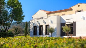 A modern building with a flat roof, large windows, and a sign reading "MINUTY". - 2 BEDROOM HOUSE IN PORT COGOLIN (with pontoon for boat) (PORT COGOLIN)
