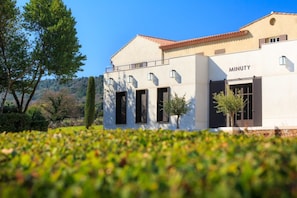 A modern building with a flat roof, large windows, and a sign reading "MINUTY".