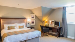 Una habitación de hotel con una cama grande, un escritorio con ordenador y una televisión.