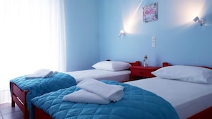 A hotel room with two beds, a red nightstand, a wall-mounted light, and a window with sheer curtains. - Hotel Asimina (Zakynthos)