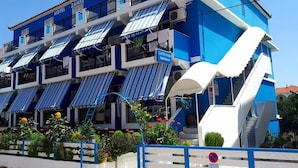A hotel with multiple balconies, a staircase, and outdoor seating areas. - Hotel Asimina (Zakynthos)