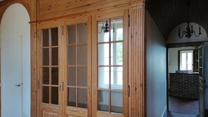 Un pasillo con paneles de madera, una puerta blanca y una pared de ladrillo.