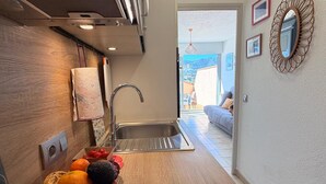 Een keuken met een moderne kraan, een houten aanrecht en uitzicht op een balkon met een bank.