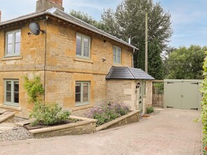A stone building with multiple windows and a small attached structure with a door. - 4 Lower Folley (Chipping Campden)