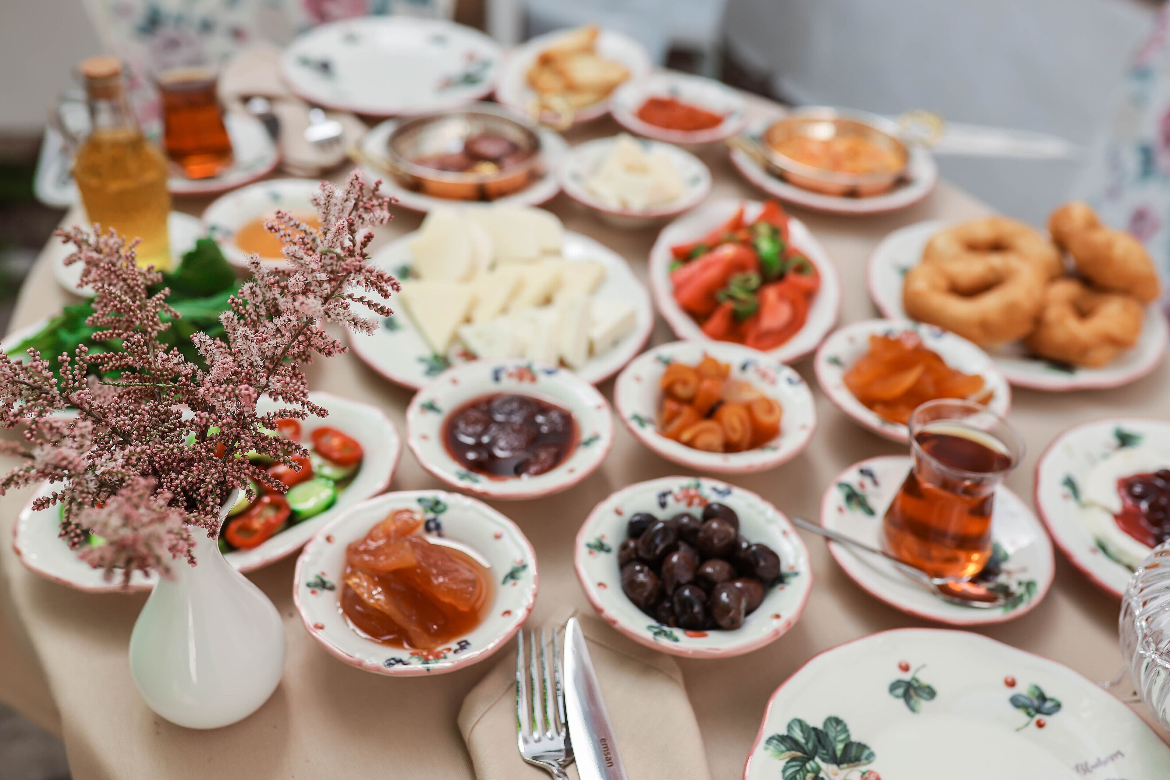 A table with various dishes and a bottle of tea.