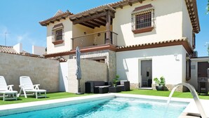Un bâtiment à deux étages doté d’une piscine, d’un espace extérieur aménagé et d’une terrasse couverte.