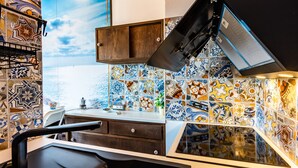 A kitchen with a tiled backsplash, a wooden cabinet, and a black countertop. - Studio 'Mono Le Lecce 38B' with Pool and Balcony (Capoliveri)