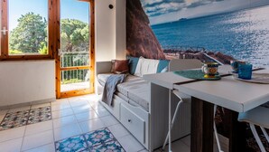 A room with a bed, a table, a view of the sea, and a balcony. - Studio 'Mono Le Lecce 38B' with Pool and Balcony (Capoliveri)