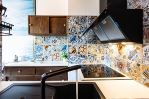 A kitchen with a tiled backsplash, a wooden cabinet, and a modern faucet.
