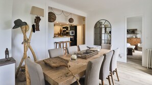 Ein Essbereich mit Holztisch, Stühlen und rustikalen Einrichtungsgegenständen, darunter ein Hut auf einem Ständer.