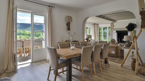 Ein Essbereich mit Holztisch, Stühlen und Blick ins Freie.