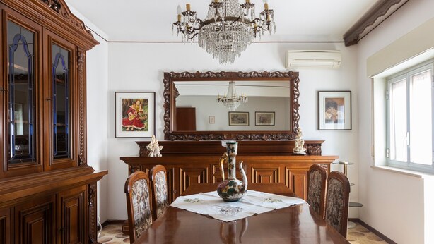 A dining room with a wooden table, chairs, a chandelier, a large mirror, and a cabinet. - Apartment 'tra mare e montagna' with Mountain View, Terrace & Balcony (Gaggi)
