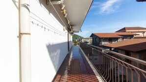 A narrow corridor with a tiled floor, a white wall, and a metal railing. - Apartment 'tra mare e montagna' with Mountain View, Terrace & Balcony (Gaggi)