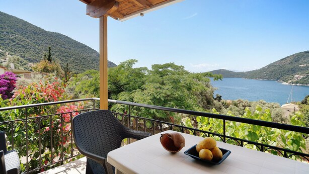 A balcony with a table, chairs, and a view of a lake and mountains. - Vardia Studio B: Sea View, Balcony, and Wi-Fi Close to the Beach (?e???da)