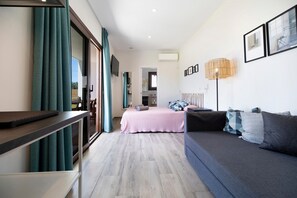 A modern bedroom with a bed, sofa, and a desk.
