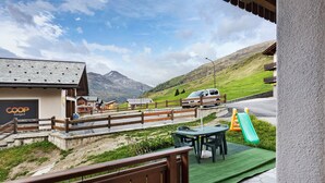 Een hotel met uitzicht op de bergen, terras en een speeltuin voor kinderen.