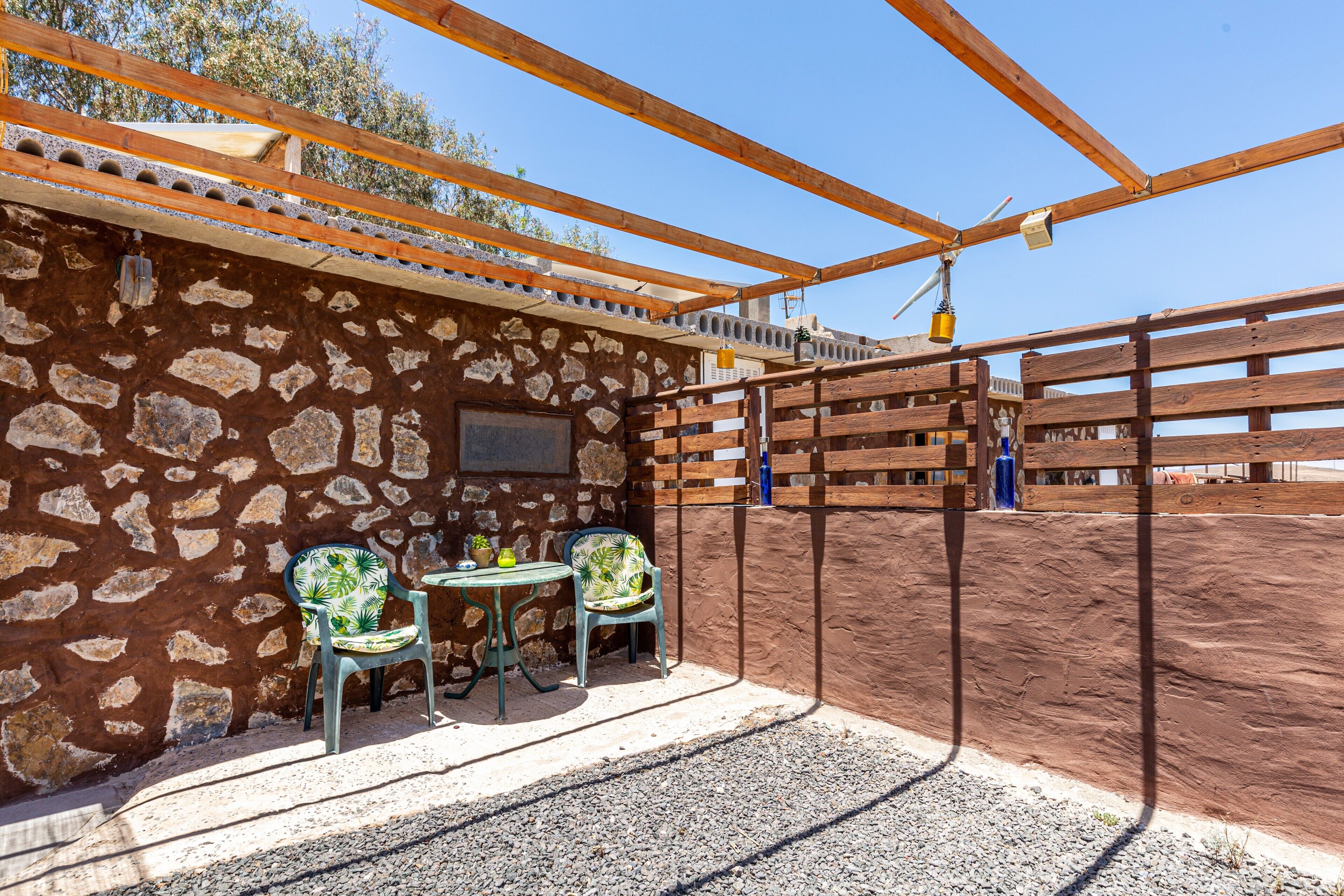 Un establo con pared de piedra, vigas de madera y zona vallada.