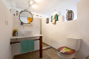 Un baño con lavamanos, espejo y retrete blanco.