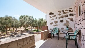A balcony with stone walls, a small table with chairs, and a view of trees. - Adults-Only Holiday Home Alma Eco-Rustic with Shared Pool and Terrace (La Fuentita)