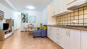 Ein kompakter Wohnbereich mit Küchenzeile, Essbereich und einer Sitzecke mit Sofa.