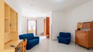 Ein modernes Wohnzimmer mit einem Holzkasten, zwei blauen Sofas, einem Holztisch und einem Sessel.
