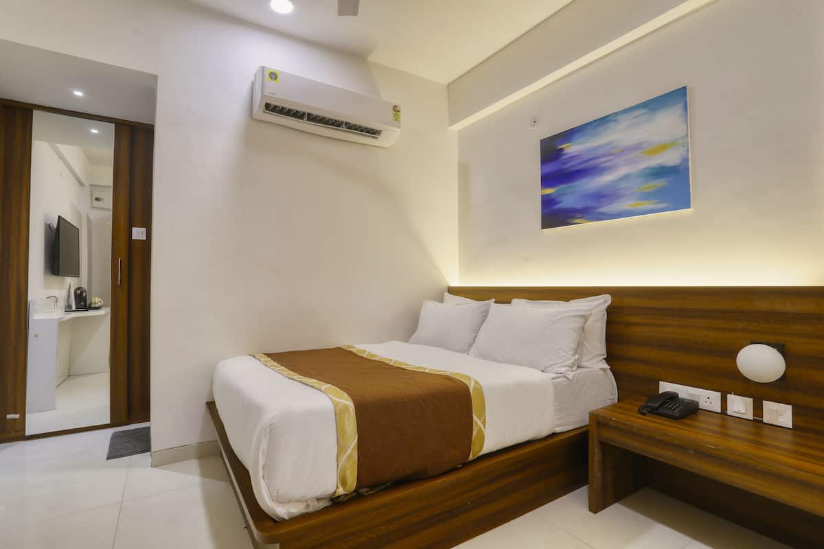 Une chambre d’hôtel avec un lit, une table de chevet et un tableau au mur.