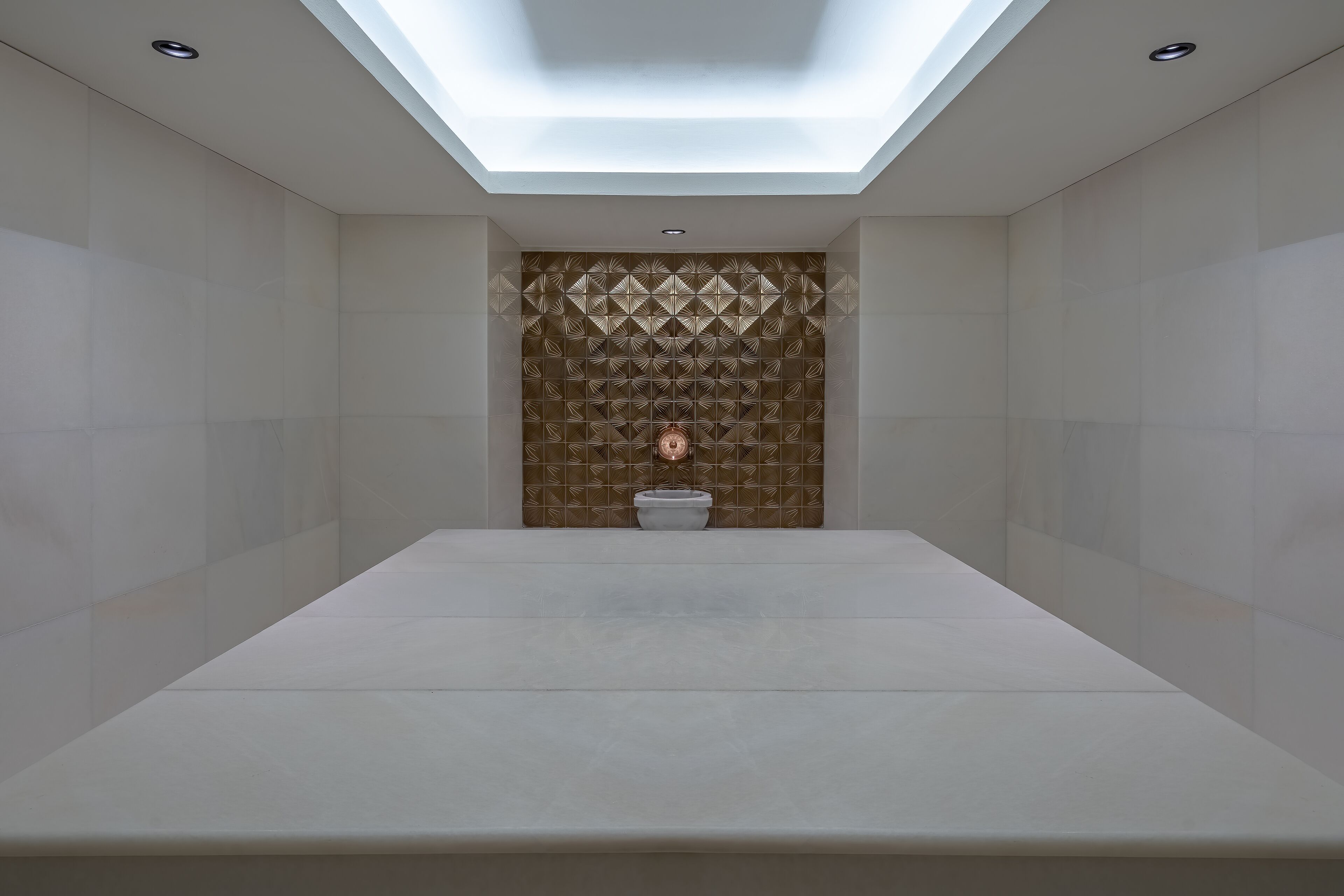 Un baño moderno con tragaluz, un diseño de pared con patrón geométrico y un estilo minimalista.